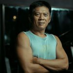 Fit man standing in the gym with arms crossed