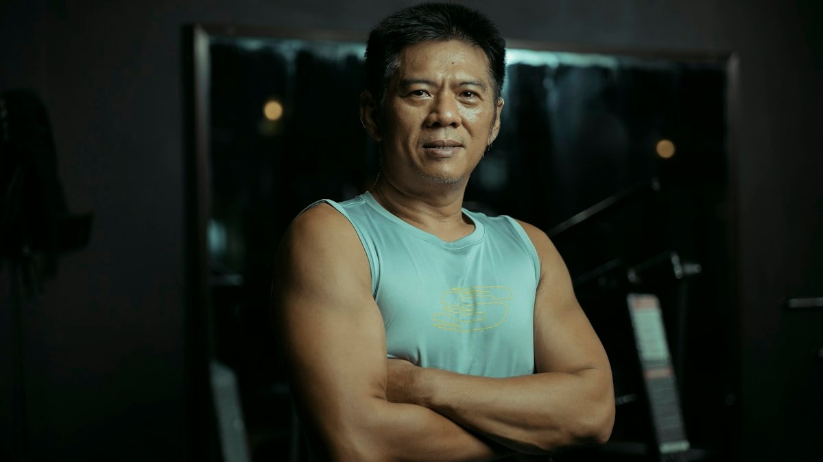Fit man standing in the gym with arms crossed